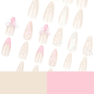 Faux ongles roses avec nœuds 3D, perles et design French de forme amande