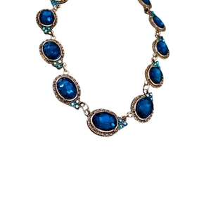 Collier vintage avec cristal ovale bleu et petits strass sur une monture en bronze