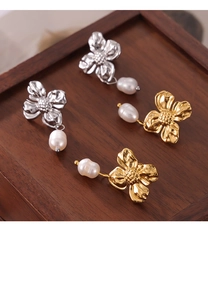 Detailed view of floral texture pearl earrings in gold and silver metal finishes