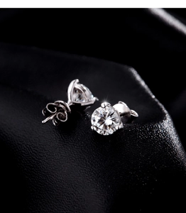 Macro shot of 1 carat moissanite stud earring with classic four-prong setting and butterfly back