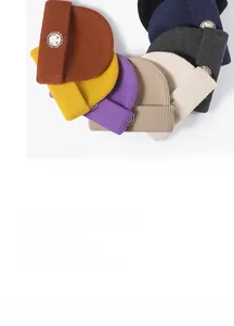 Close-up of assorted colorful knitted beanies with embroidered smiley face patches