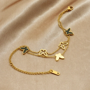 Double-layered gold stainless steel butterfly chain bracelet on champagne silk background