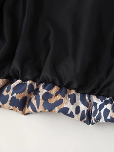 Detailed macro view of leopard print ribbed hem stitching on trendy baseball jacket