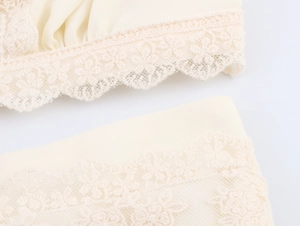 Détail de la broderie en dentelle abricot et du tissu en mousseline sur la robe