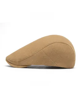 Side view detail of a classic camel newsboy cap with multi-panel stitching and short brim