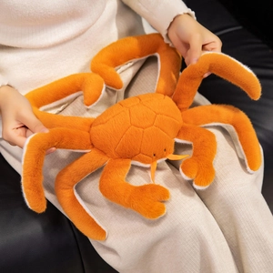 Realistic orange king crab plush pillow held by a model for size and soft texture reference