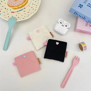 Detailed view of quilted heart pattern mini storage pouches in white, black and pink colors