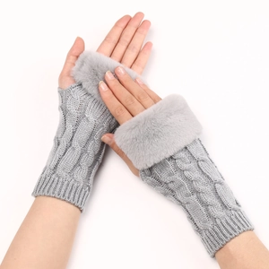 Detail of grey cable knit fingerless gloves featuring soft faux fur trim and textured weave