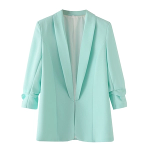 Detail van de muntgroene blazer met geplooide mouwen en gladde stofstructuur