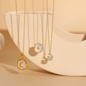 Detailed view of three 14K gold plated necklaces featuring shell and zircon star moon pendants
