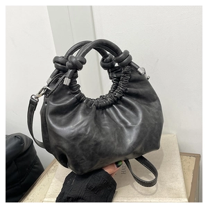 Close-up of black knotted leather cloud bag with natural pleats and silver metal hardware