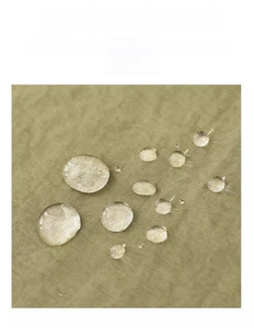 Macro detail of waterproof Taslan apron fabric with water droplets on green surface