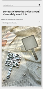 Detail of silver handheld mirror featuring a unique liquid ripple texture on the back