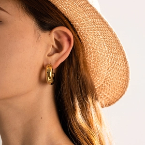 Close-up of a model wearing chunky 18K gold plated hollow C-shape hoop earrings