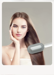 Detail of female model using ergonomic massage hairbrush for smooth long hair care