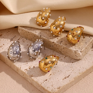 Detail view of water drop earrings in gold and silver with zircon and pearls