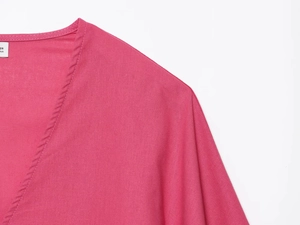 Détail du col en V et des coutures sur ce haut asymétrique en mélange de lin rose