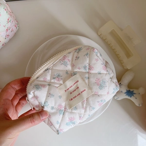 Close-up of pink floral quilted cotton cosmetic bag with chic fabric label detail