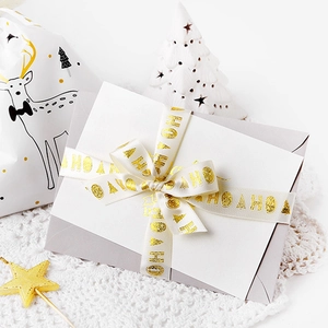 White Christmas ribbon with gold HOHO lettering and festive gift packaging decor