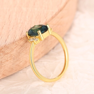 Macro detail of a vintage oval green gemstone ring with side diamonds on gold band