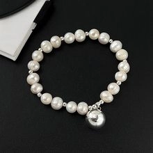 Close-up of natural freshwater pearl bracelet with a silver metal spherical pendant