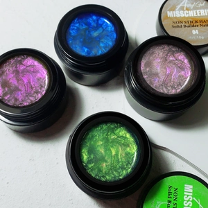 Detailed view of four colorful non-stick solid builder nail gels with shimmering glitter texture