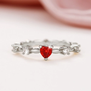 Elegant silver ring with a heart-shaped red zircon and sparkling white side stones