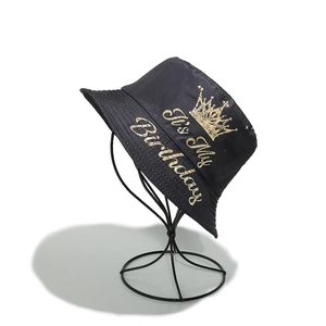 Close-up of black fisherman hat with golden It's My Birthday print and crown design