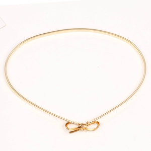 Close-up of a gold elastic spring waist belt featuring a decorative metal bow clasp