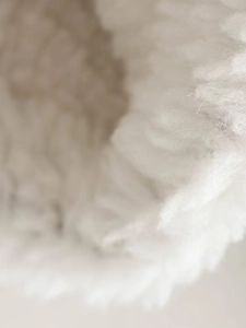 Macro shot of ivory faux fur texture on short biker jacket showing soft fibers