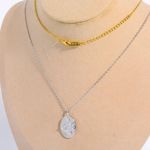 Macro detail of K18 gold clasp and oval zirconia pendant on minimalist chains