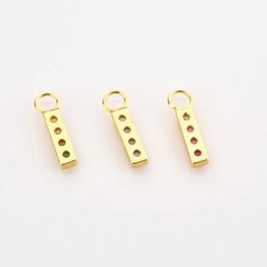 Detailed view of three gold rectangular pendants with colorful zircons on white background