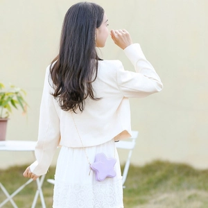 Star-shaped light purple jelly bag with gold chain strap worn by a model outdoors