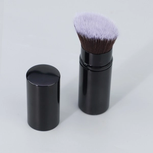 Macro view of portable angled makeup brush bristles with a black cylindrical protective cap