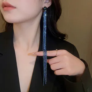 Elegant long fringe tassel earrings with blue gradient crystals on a model