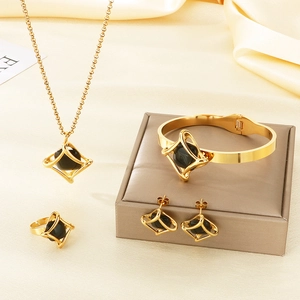 Detail of geometric rhombus jewelry set with black stones on beige silk fabric