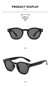 Close-up of black round frame sunglasses with grey lenses and vertical metal rivets