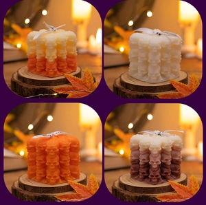 Detailed view of Halloween skull candles in various colors with maple leaf decorations