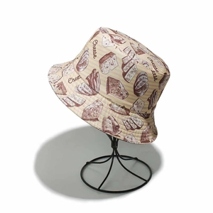 Detail of summer bucket hat featuring cheese and bread sketch prints on beige fabric