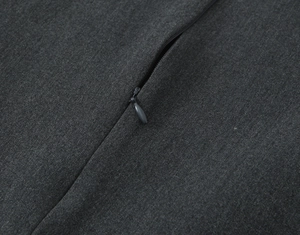Detail of invisible zipper closure on dark gray dress with premium fabric texture