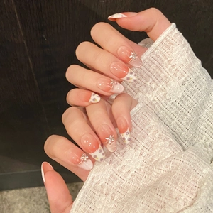 Handmade almond press-on nails with orange gradient, floral art and metal butterfly