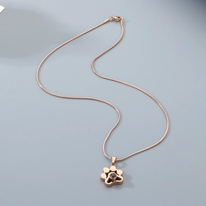 Vue détaillée du pendentif patte en or rose avec pierre de projection sur chaîne serpent