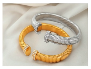 Macro shot of gold and silver Tubogas stretch bracelets with rhinestones on silk