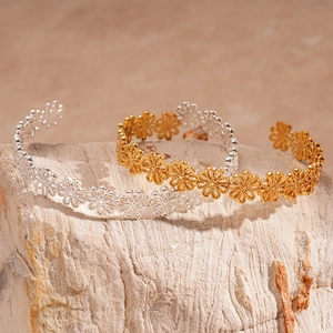 Hollow flower open cuff bracelet in gold and silver finish on natural stone background
