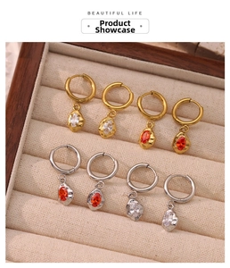 Close-up of gold and silver hoop earring set with red and white zircons in a jewelry box