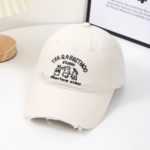 Detail of bunny embroidery and distressed holes on this cream beige baseball cap