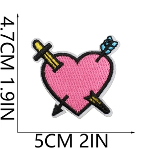Detailed view of pink heart embroidery patch with blue arrow and sword 5cm measurement