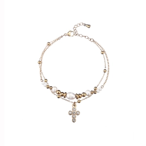 Detail of gold-plated double-layer bracelet with pearls, crystals and cross pendant