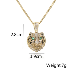 Macro detail of 18K gold plated tiger pendant with clear zircons and green stone eyes