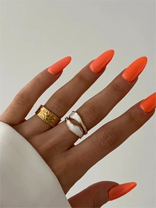 Detail of stacked 18K gold hammered ring and white enamel wave ring on a finger